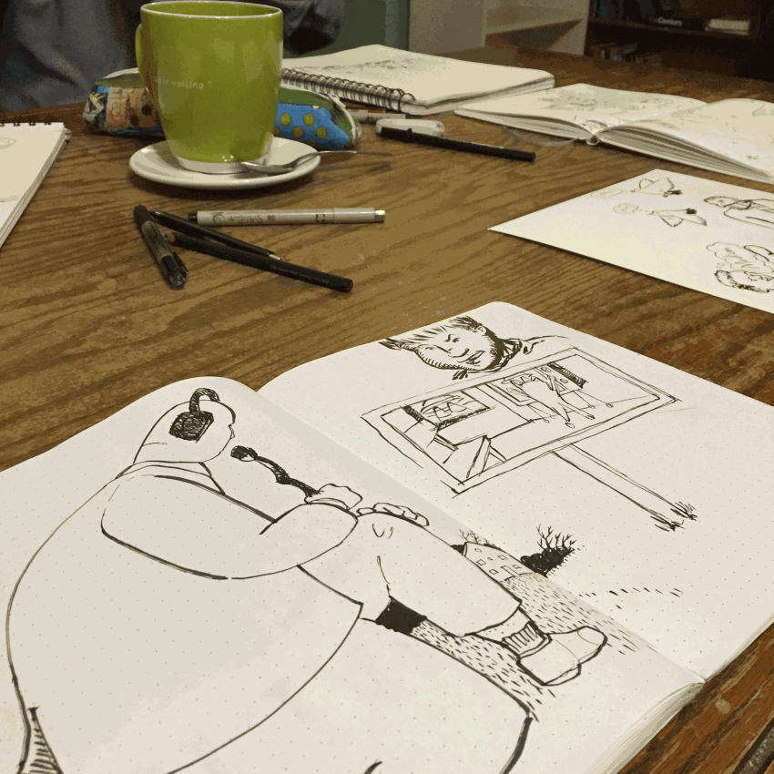 An image of sketchbooks with drawings in them open on a table.
