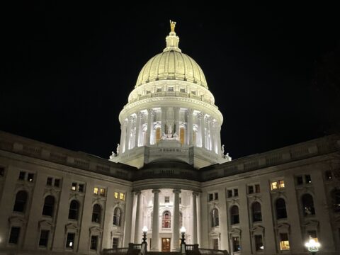 An image of the capitol building in Madison, WI lit up against the dark night sky.